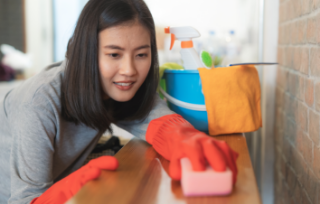 close-up-woman-cleaning-kitchen-using-cleanser-spray-cloth