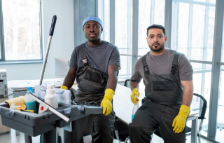 happy-young-female-twins-aprons-gloves-holding-paint-rollers-while-standing-close-one-another-front-camera-looking-you-1